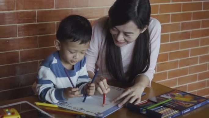 亚洲单亲妈妈和儿子的4k慢动作镜头在现代阁楼房屋中微笑着充满幸福的生活，以实现自我学习或家庭学校，家