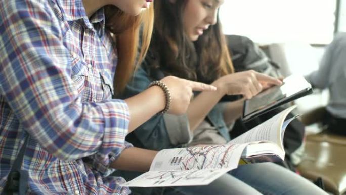 机场规划欧洲假期暑假旅行中的两名年轻女子阅读指南地图