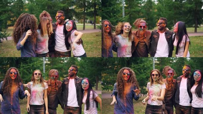 在公园草坪上的聚会上，无忧无虑的青年跳舞和跳跃的肖像互相拥抱，脸上，头发和衣服都被油漆覆盖。