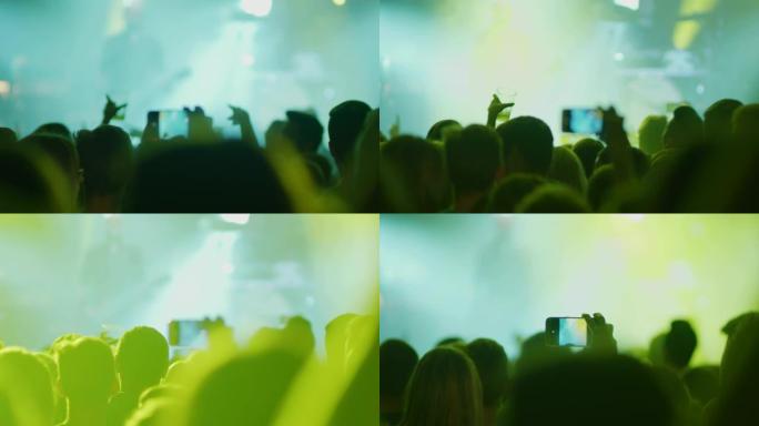 女士在人群中与照相手机一起拍摄音乐音乐会