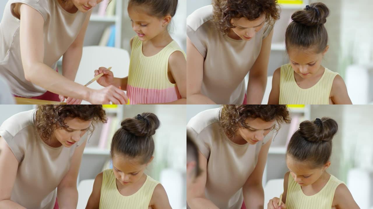 女教师帮小女孩做纸艺