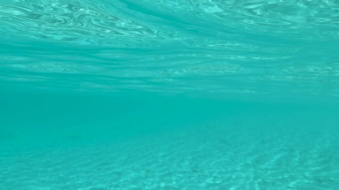 水下: 在夏季的阳光下，充满异国情调的海洋的玻璃状表面微光。