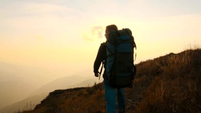 那个背着旅游背包在山上行走的人。慢动作