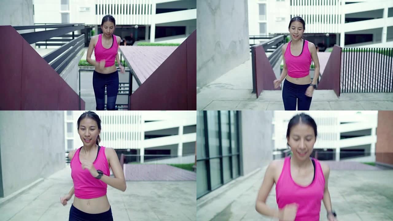 慢动作-健康美丽的年轻亚洲跑步女子穿着运动服在城市的街道上跑步和慢跑。生活方式适合和积极的女性在城市