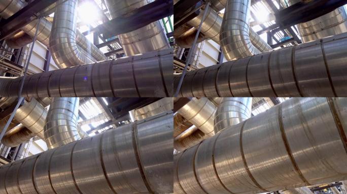 电厂中带有绝缘，标有堵头和阀门的蒸汽金属管道的平移视图