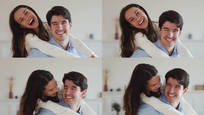 牙齿微笑的年轻夫妇一起笑着看着相机