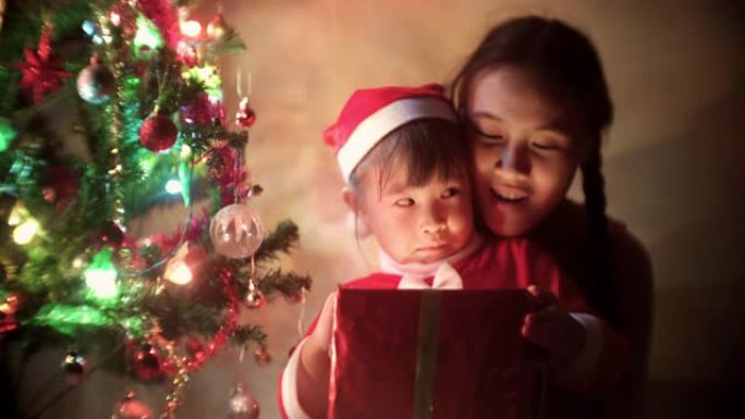 圣诞老人礼服打开礼品盒的儿童女孩在圣诞节