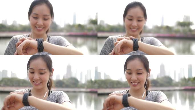 运动年轻女子在智能手表上监控她的跑步表现