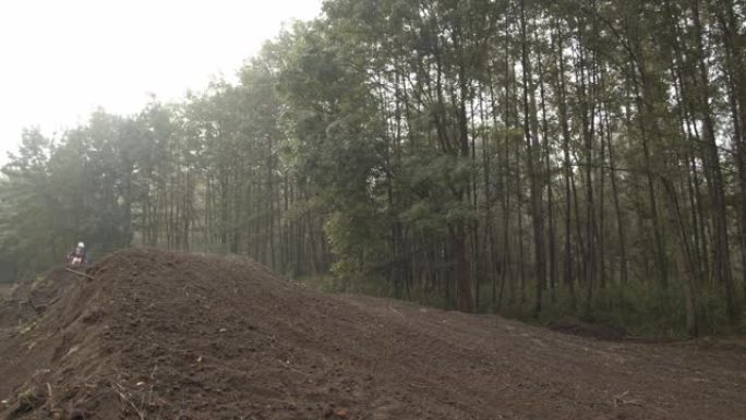 摩托车越野赛车手在赛道上跳过土墩