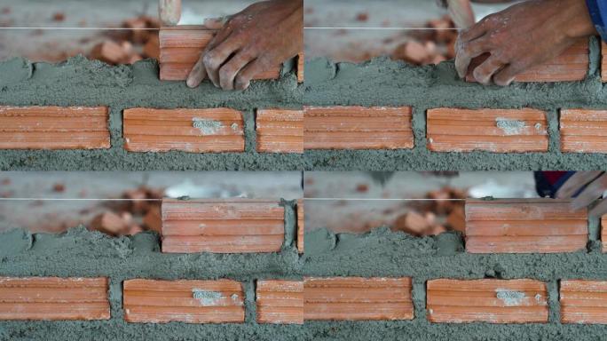 4k镜头特写手工专业建筑工人在新工业场地、建筑行业和砖石概念中砌砖的场景