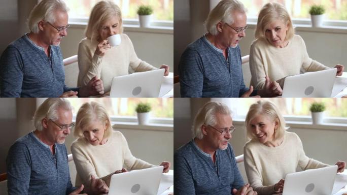 开朗的老年妻子喝咖啡与丈夫用笔记本电脑聊天