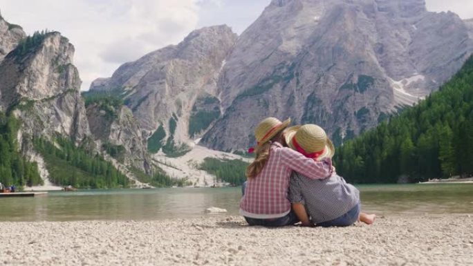 两个小姑娘，头上戴着一顶草帽，在湖边，互相嬉戏，欣赏风景，她们相拥，因为彼此相爱。