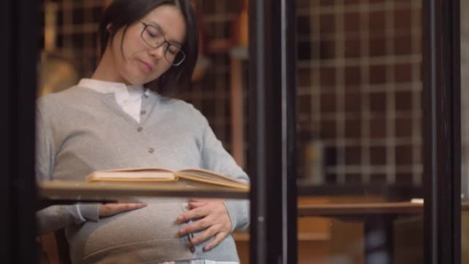 中国孕妇在窗口看书