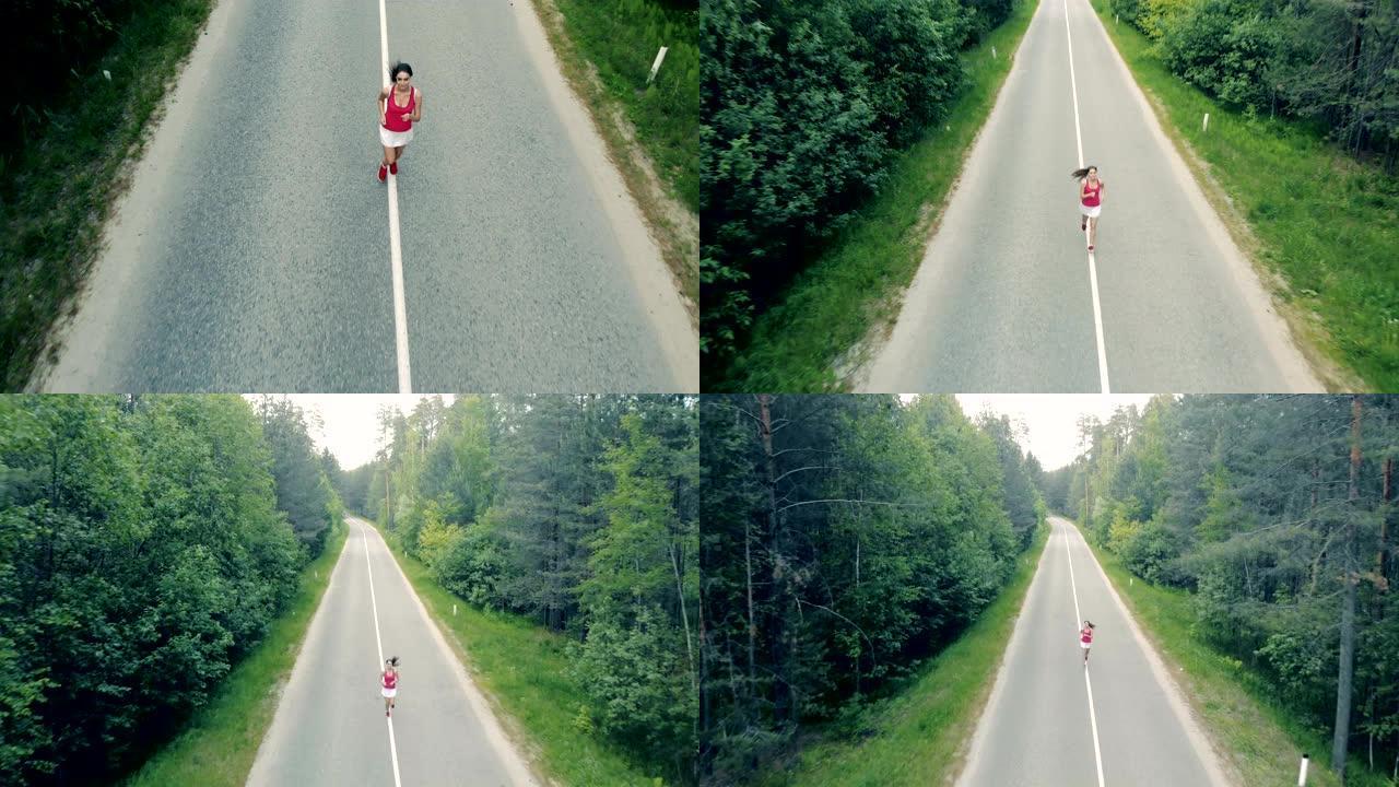 一个漂亮的年轻女子在森林里高速公路上奔跑的俯视图。空中。