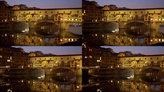 意大利佛罗伦萨韦基奥桥桥。傍晚的黄色桥梁在阿诺河上反射。全景拍摄，4K