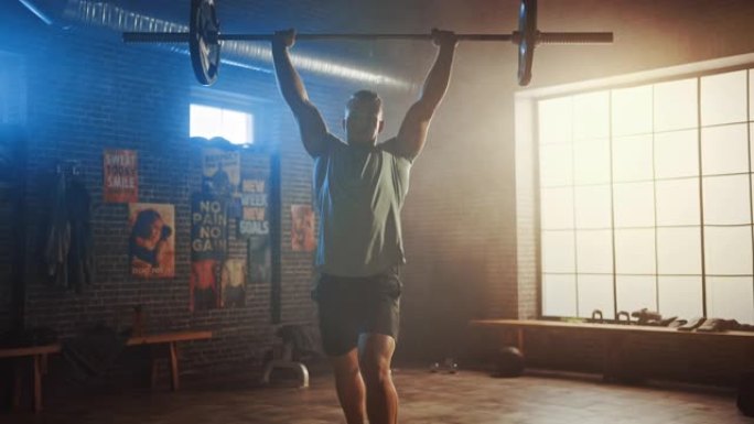 英俊的肌肉男在一个真正的小型健身房里用杠铃进行头顶硬拉。运动员训练手臂肌肉，用杠铃锻炼。在铁杆健身房