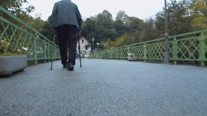 拉老人过桥老人拄拐杖蹒跚前行走路