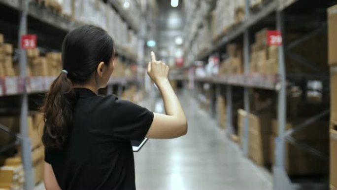 亚洲女工在仓库检查用品