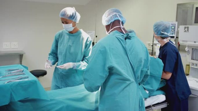 护士用外科医生的医疗器械作为手术团队在手术室对患者进行工作