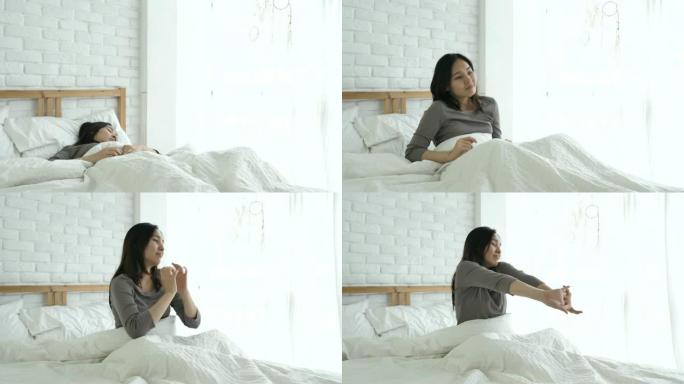 亚洲妇女醒来并在床上伸展