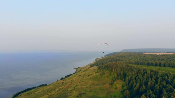 海岸线和沿其滑行的帆翼。跳伞运动员在天空中飞翔。