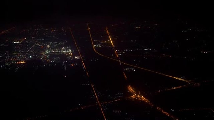 4k镜头场景从机场起飞后，晚上飞机在城市上空飞行的俯视图，旅行和运输概念