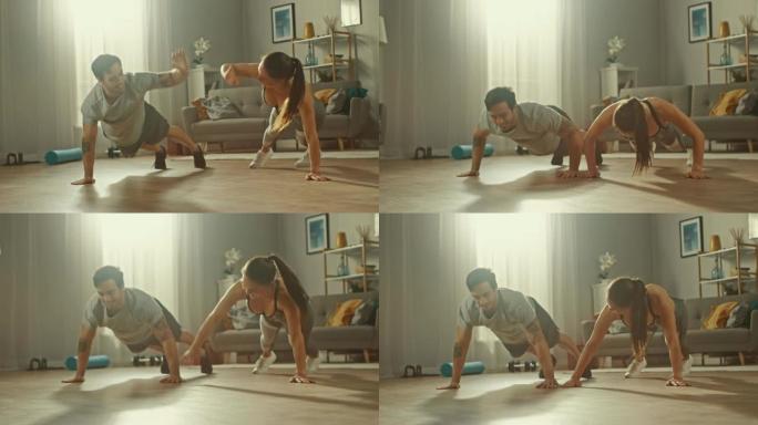 慢动作拍摄一对强壮而美丽的运动健身夫妇穿着运动服做俯卧撑练习，并在明亮宽敞的客厅与简约的内部给对方击