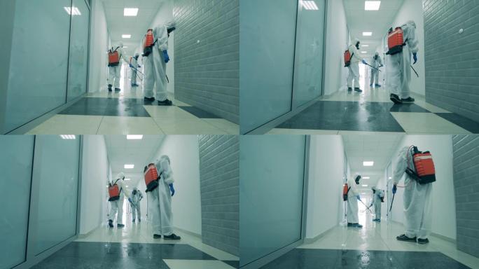 人们使用喷雾机对走廊进行消毒。