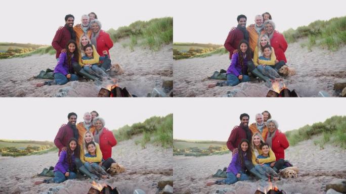 在冬季海滩上坐着火的多代家庭肖像-慢动作拍摄