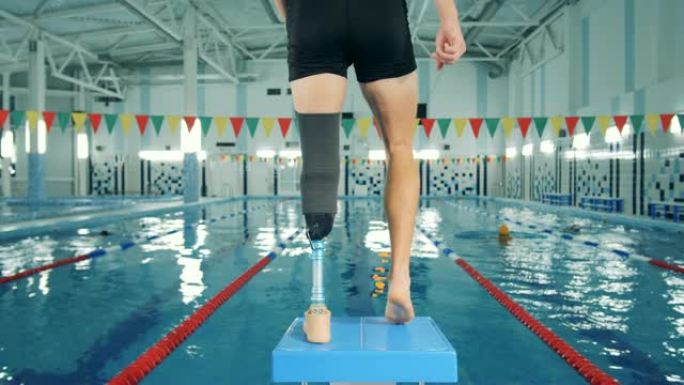 男性游泳运动员，腿部假肢，后视图。