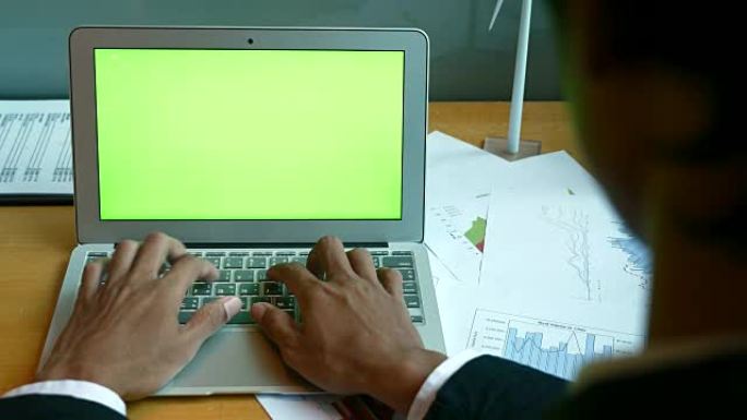 商人使用笔记本电脑分析财务绿屏