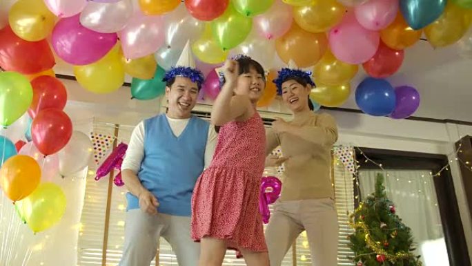 快乐的年轻亚洲家庭在家里的派对活动中一起跳舞。快乐的家庭庆祝除夕。