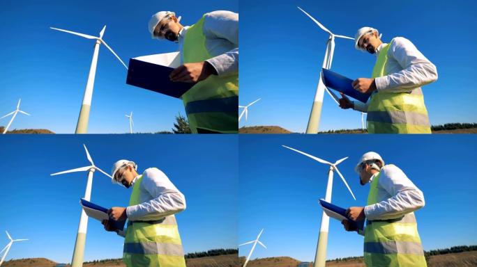 旋转风力涡轮机和一个男性专家站在他们附近。清洁、环保的能源概念。