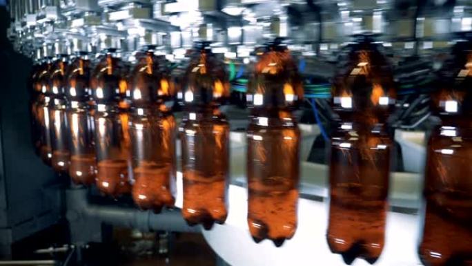 啤酒从工厂机器倒入旋转塑料瓶中