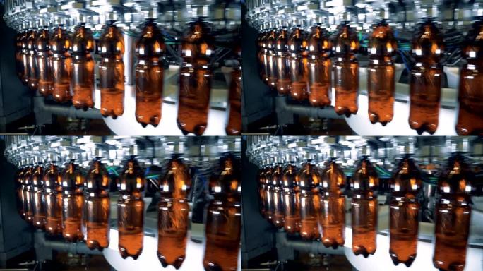 啤酒从工厂机器倒入旋转塑料瓶中