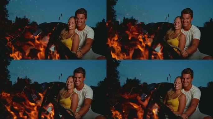 复制空间: 在浪漫的夏日夜晚，幸福的夫妻坐在篝火旁。