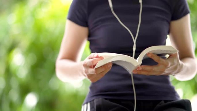 女人看书和用耳机听音乐的手持镜头