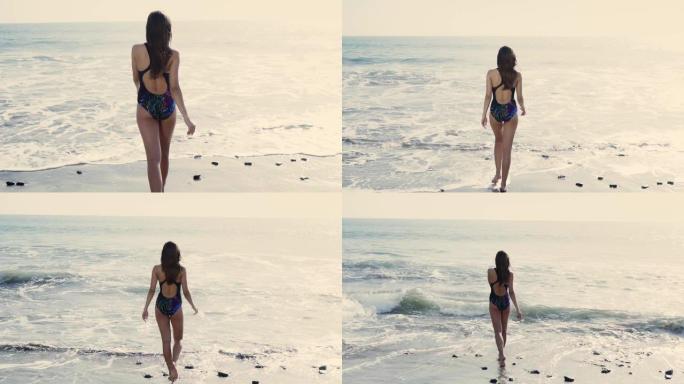 享受大海的年轻女子。玩波浪