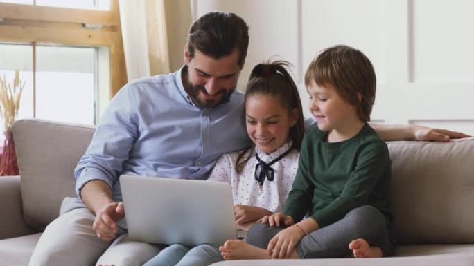 快乐的爸爸和孩子们在家里用笔记本电脑玩得开心