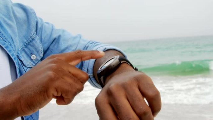 在海滩上使用智能手表的非洲裔美国人的中间部分4k