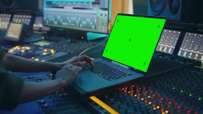 女艺术家，音乐家，制作人，音频工程师在音乐唱片工作室工作，制作新专辑，使用绿屏笔记本电脑，控制台进行