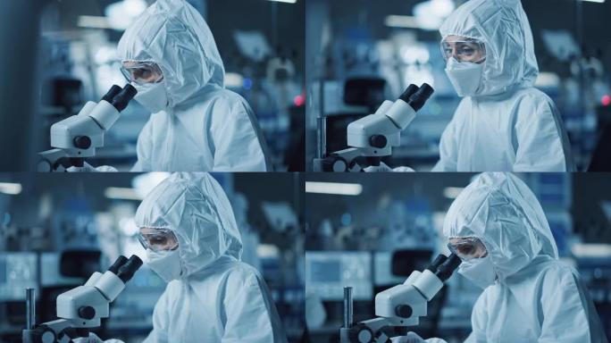 研究工厂洁净室: 工程师/科学家穿着工作服，使用显微镜检查样品，为医疗和高精度电子行业开发高科技现代