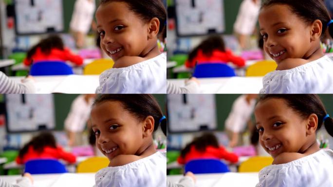 快乐高加索女学生在教室里看着相机的后视图4k