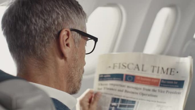 成熟的商人在喷气式飞机上阅读报纸