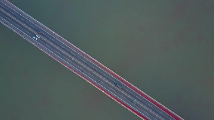 空中飞行: 在越南一条繁忙的公路桥上方穿越泥泞的河流。