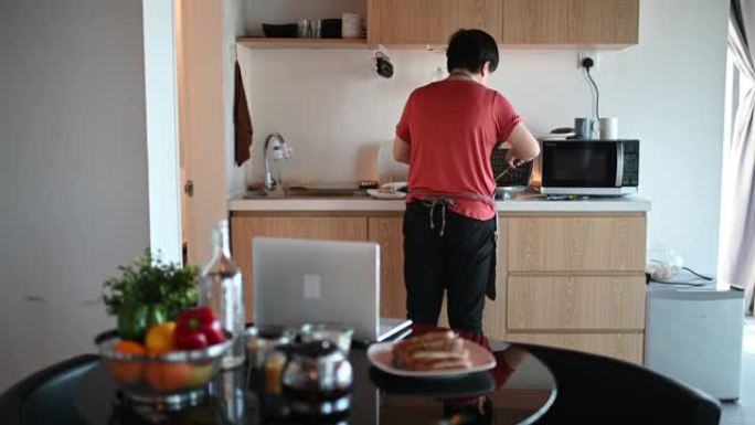 一名亚洲华裔妇女早上在厨房为家人准备早餐华夫饼