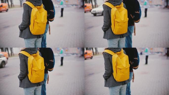 在寒冷的下雪的冬日里，当地男人和女人带着明亮的黄色背包站在一起的背景图。