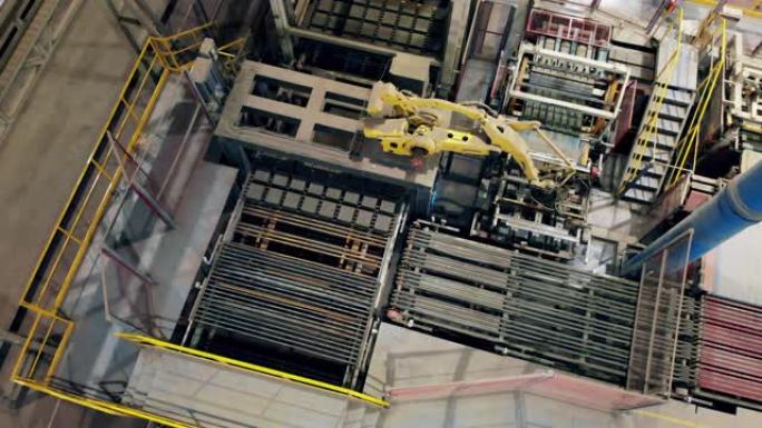 机器人手臂在amodern工厂车间移动成批砖的俯视图。