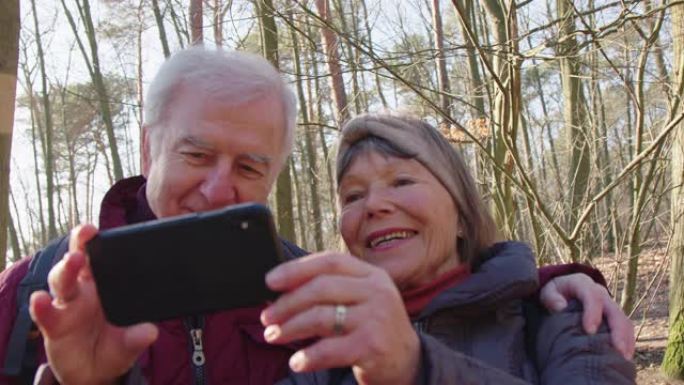 微笑的老年人用智能手机自拍