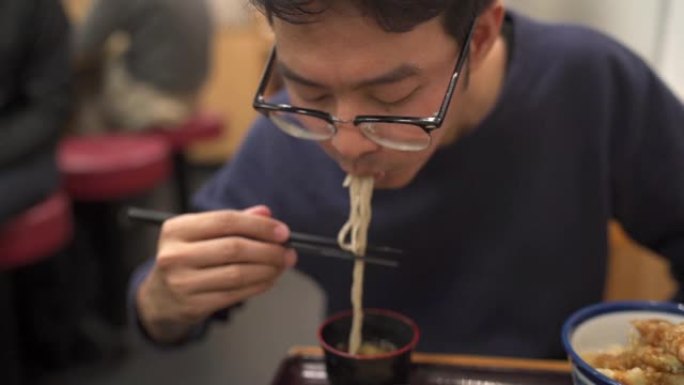 亚洲男子吃日本食物套装，冷荞麦面面条和虾天妇罗